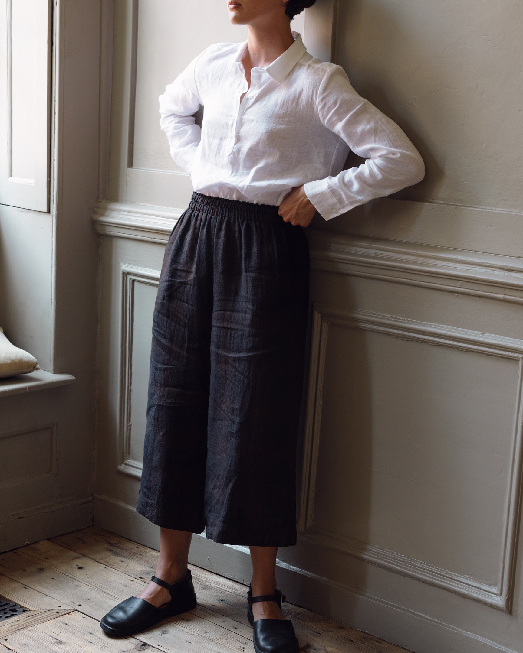 Model wearing Pyne & Smith women's linen culottes in black with midi length and elasticated waistband 