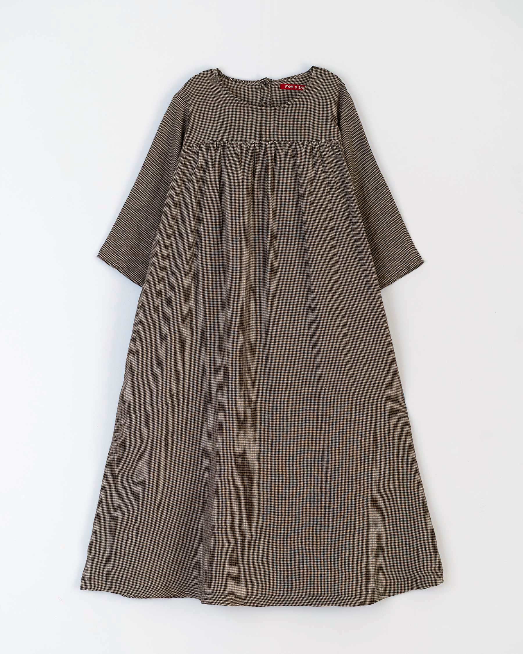 Flat lay of A line midi linen dress without waist belt showing three quarter length sleeves and A line shape
