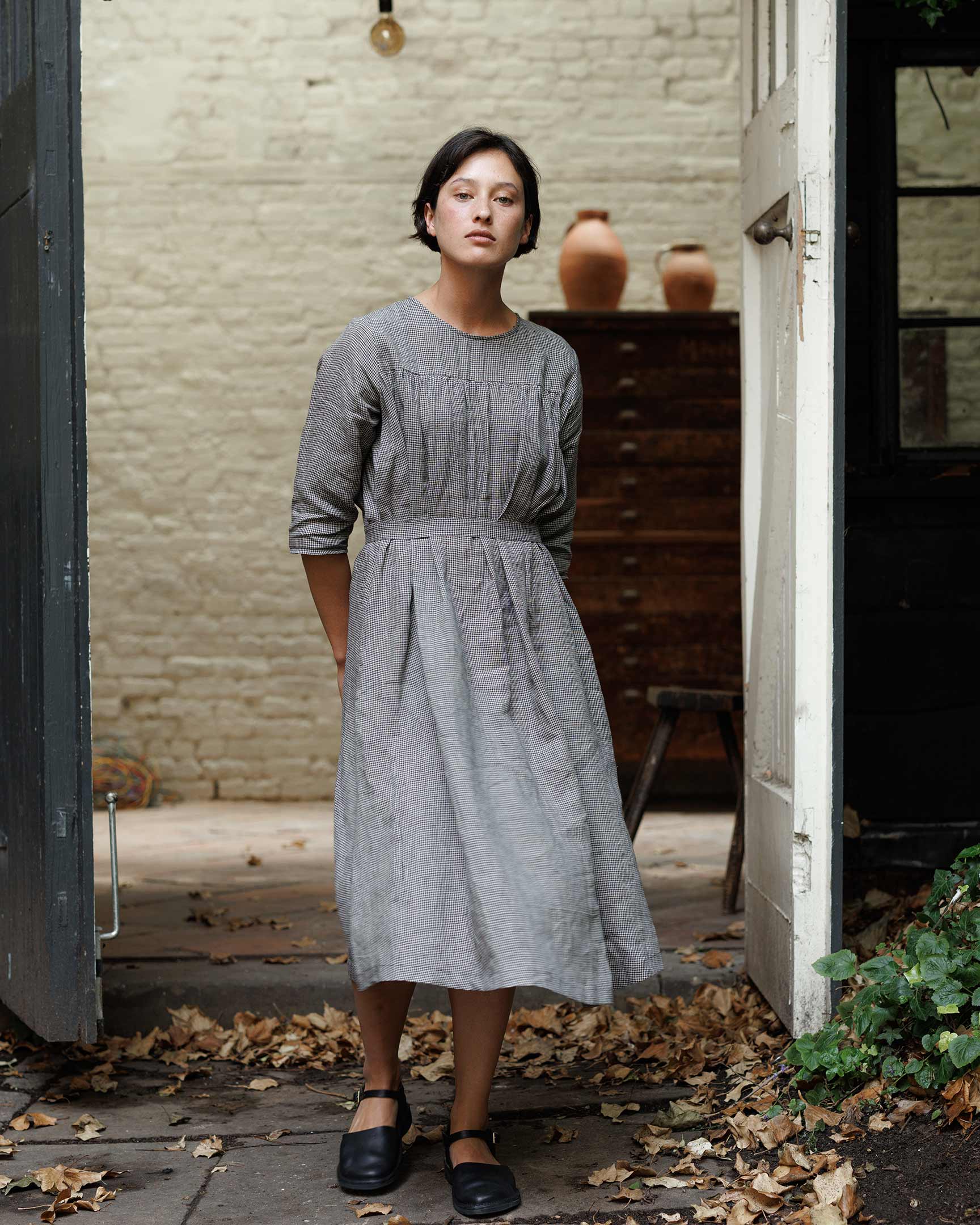Model wearing A line, flowing linen dress with waist belt in black and gray Hazlitt's Check