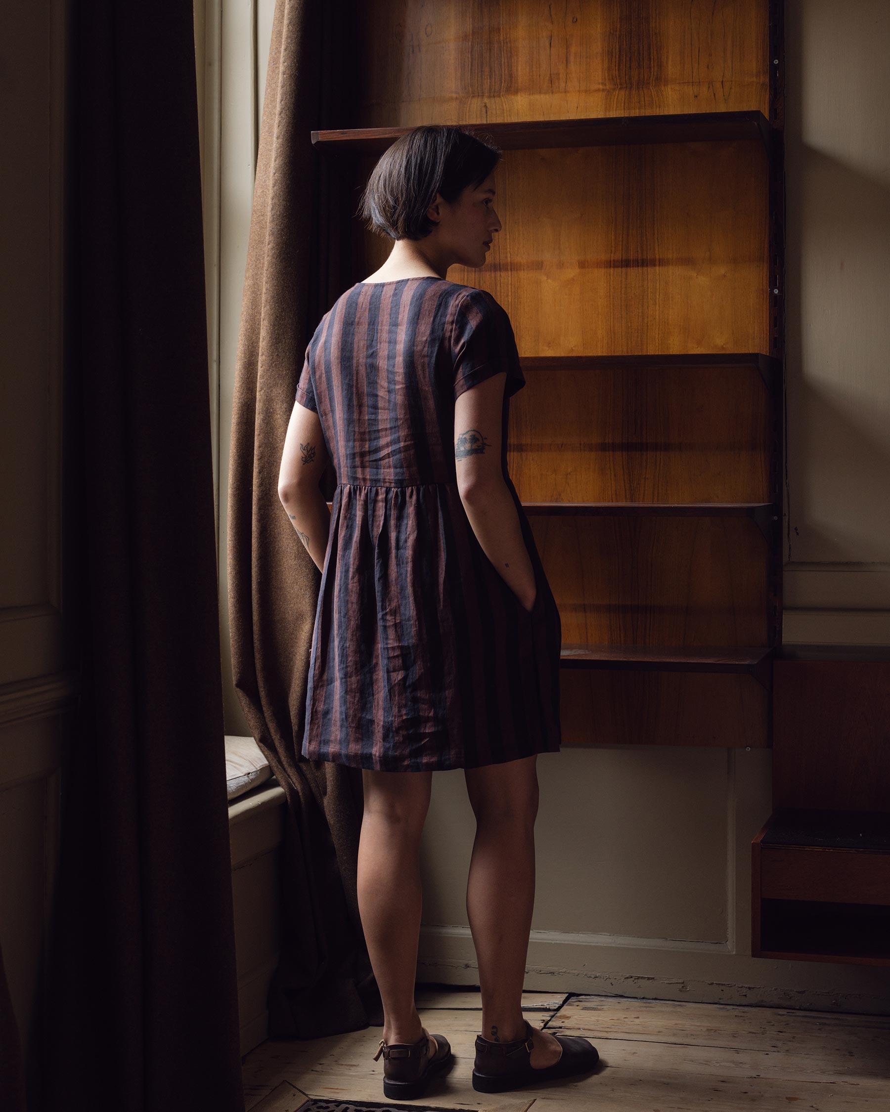 back view of button up linen dress in cocoa and black stripe