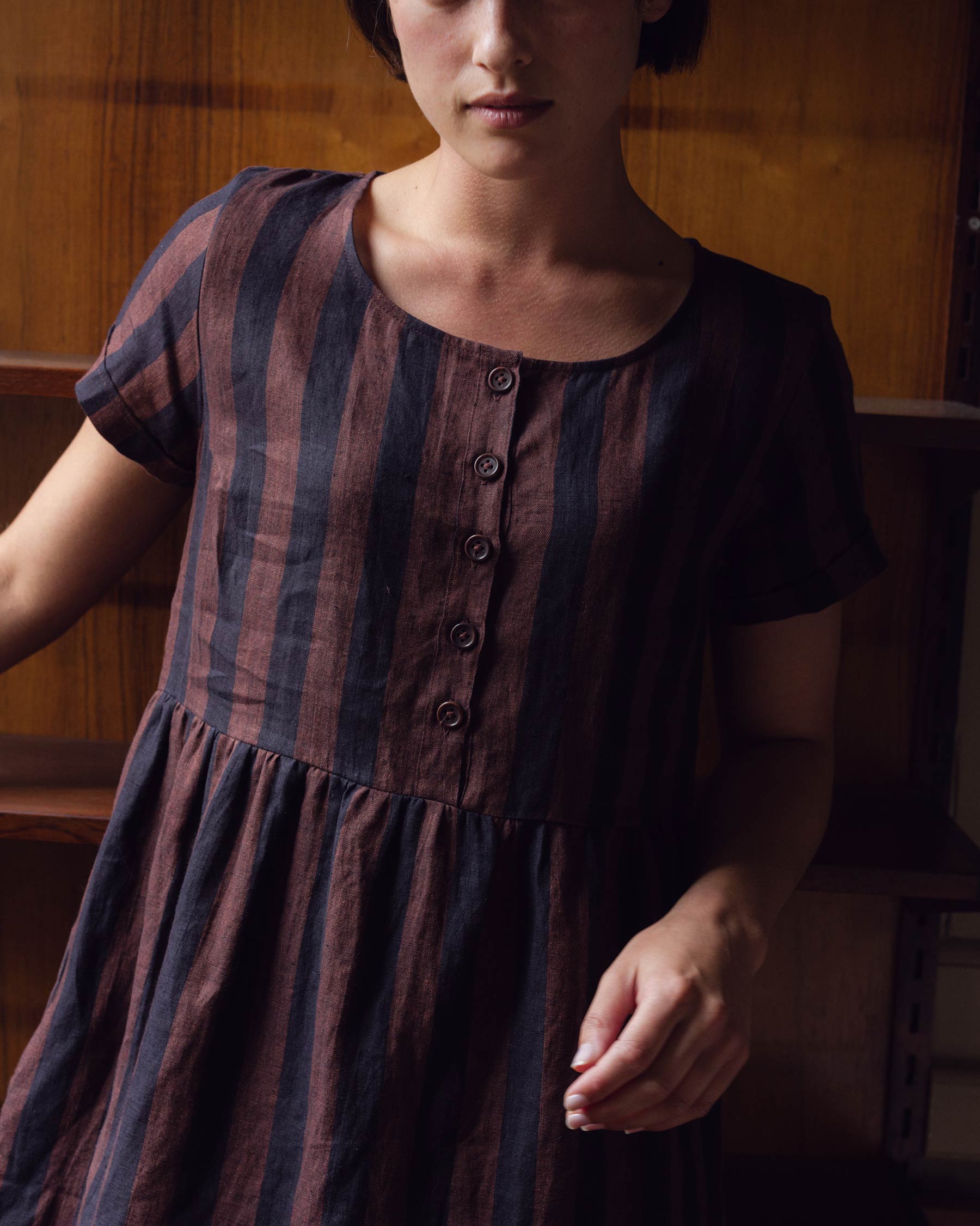 Close up of button up bodice on cocoa and black stripe linen dress