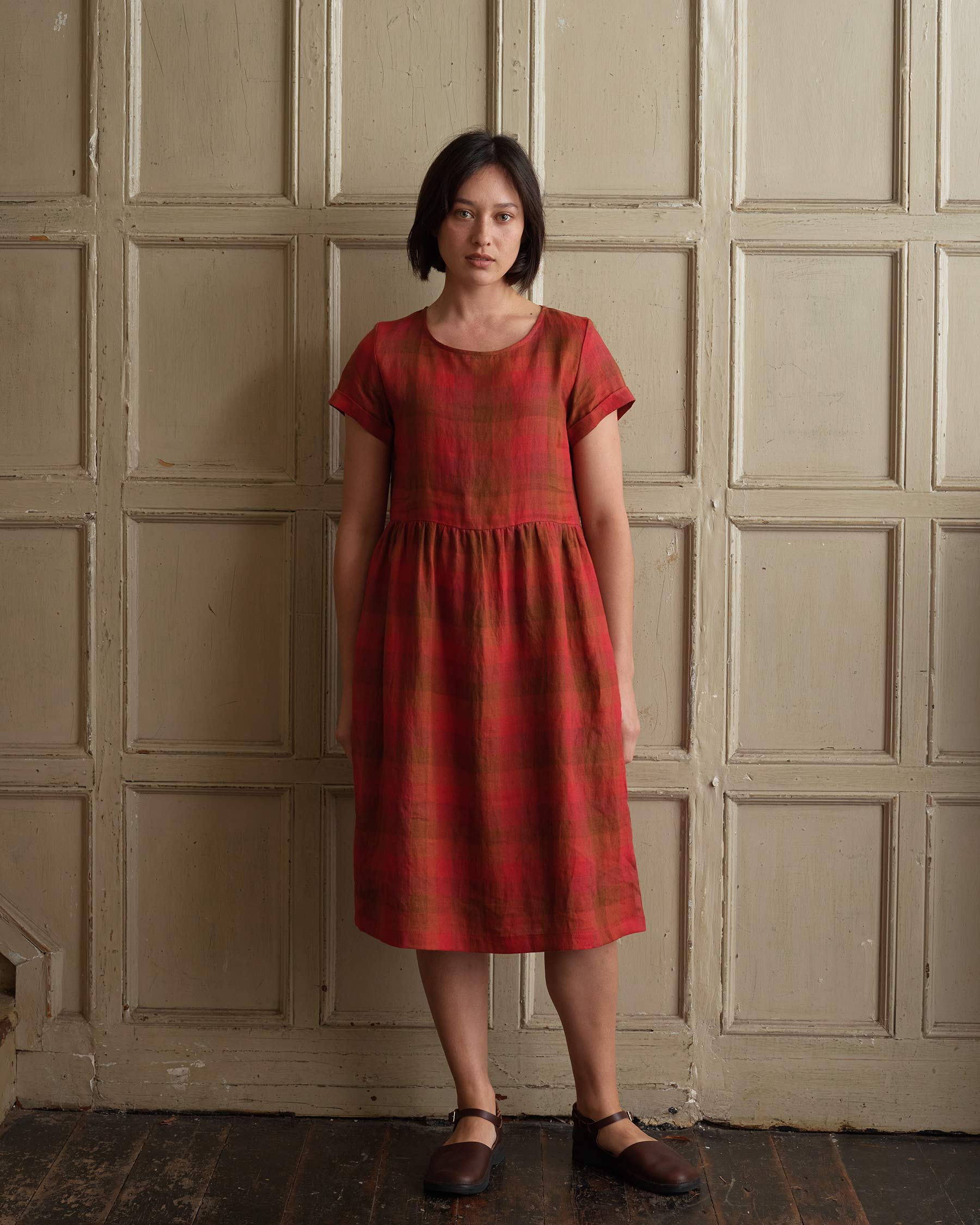 Model showing front view of linen midi day dress with pockets in red Paloma Check