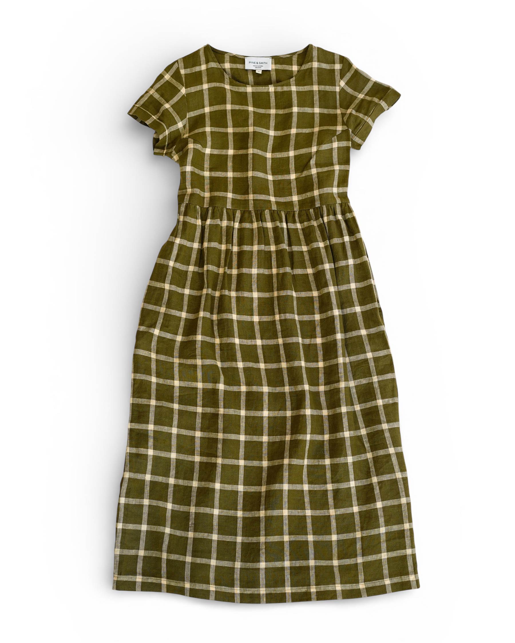 The No.17 Full Length Linen Tea Dress in Celtic Plaid by Pyne and Smith Clothiers features a green, white, and yellow plaid, round neckline, fitted waist, short sleeves, and pockets—all displayed flat on a white background.