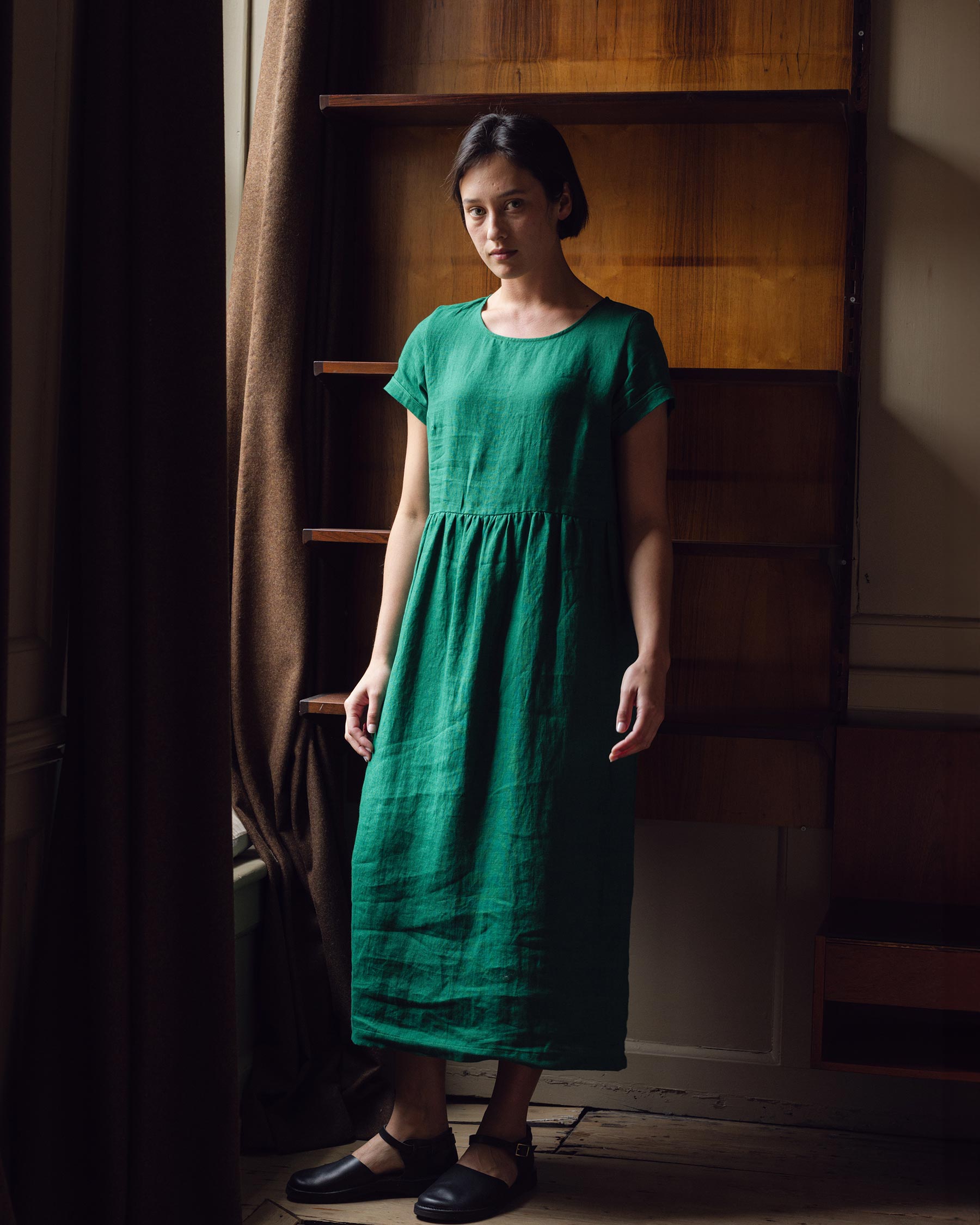 Front view of model wearing full length linen tea dress in viridian green
