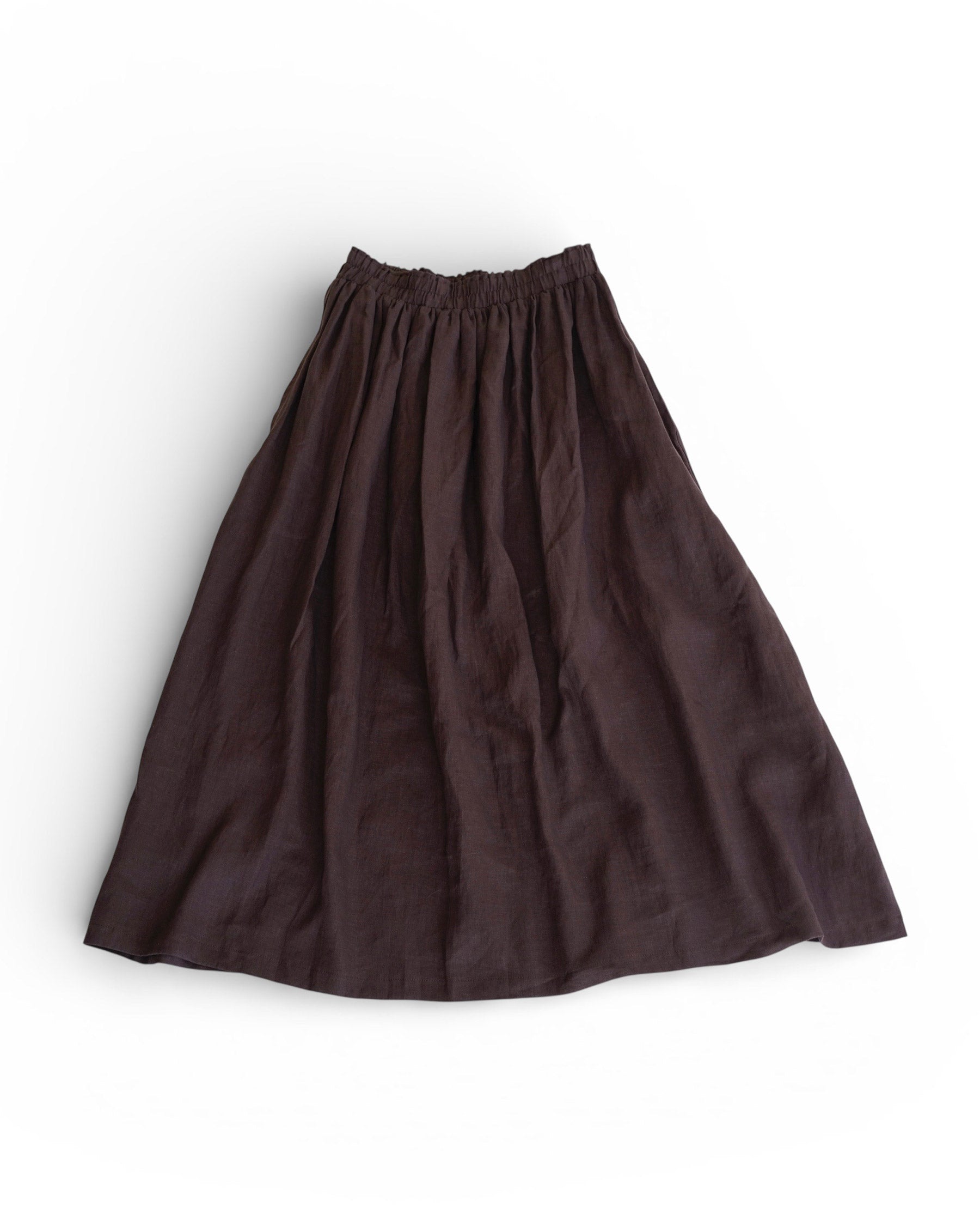 The Linen Maxi Skirt No.12 in Chocolate Plum by Pyne and Smith Clothiers is a dark brown A-line skirt with an elastic waist, crafted from lightweight European flax linen, shown flat on a white background.