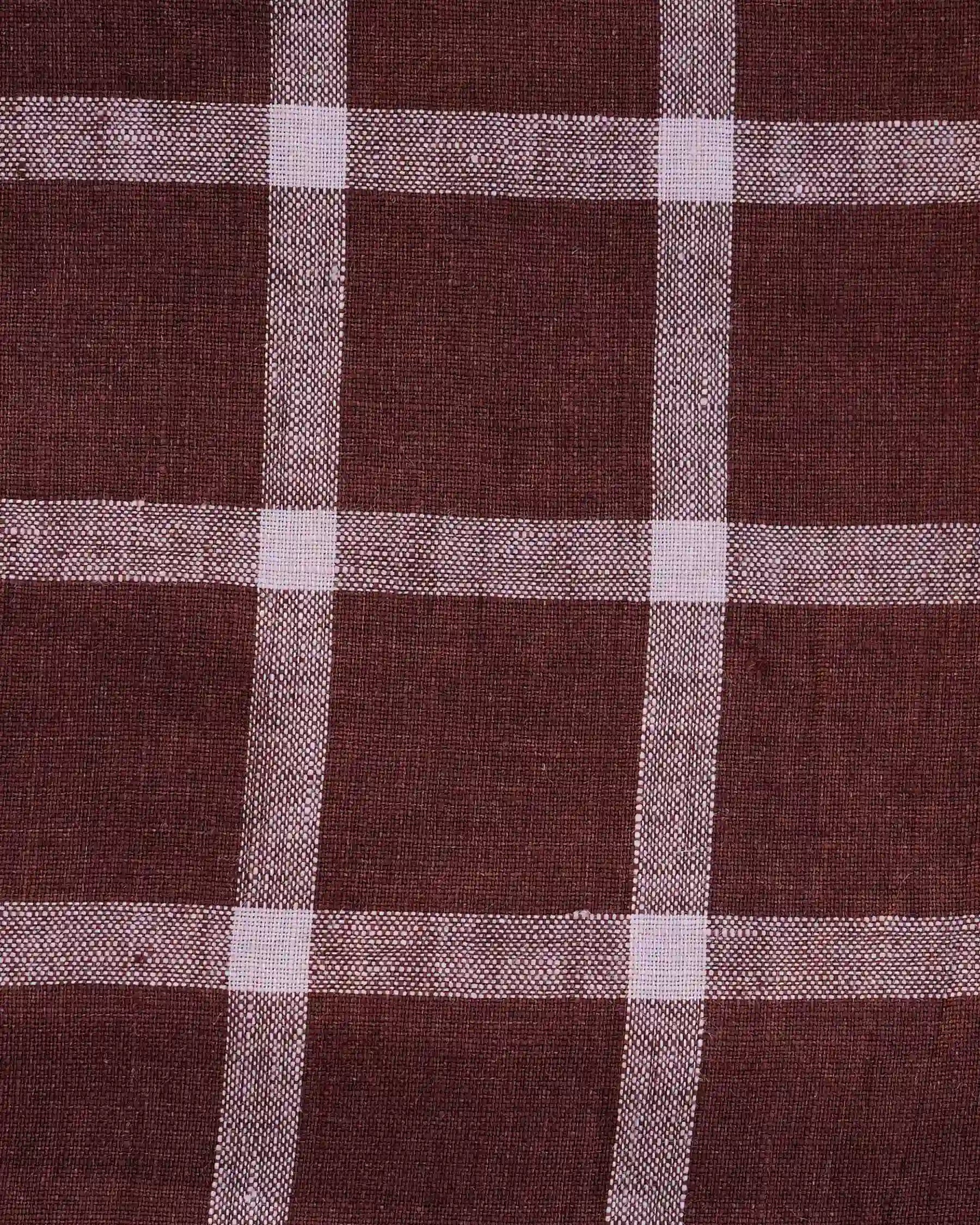 A close-up of Pyne and Smith Clothiers’ No.15 Linen Day Dress in Neapolitan, made from European linen with a brown checkered pattern and intersecting white lines.