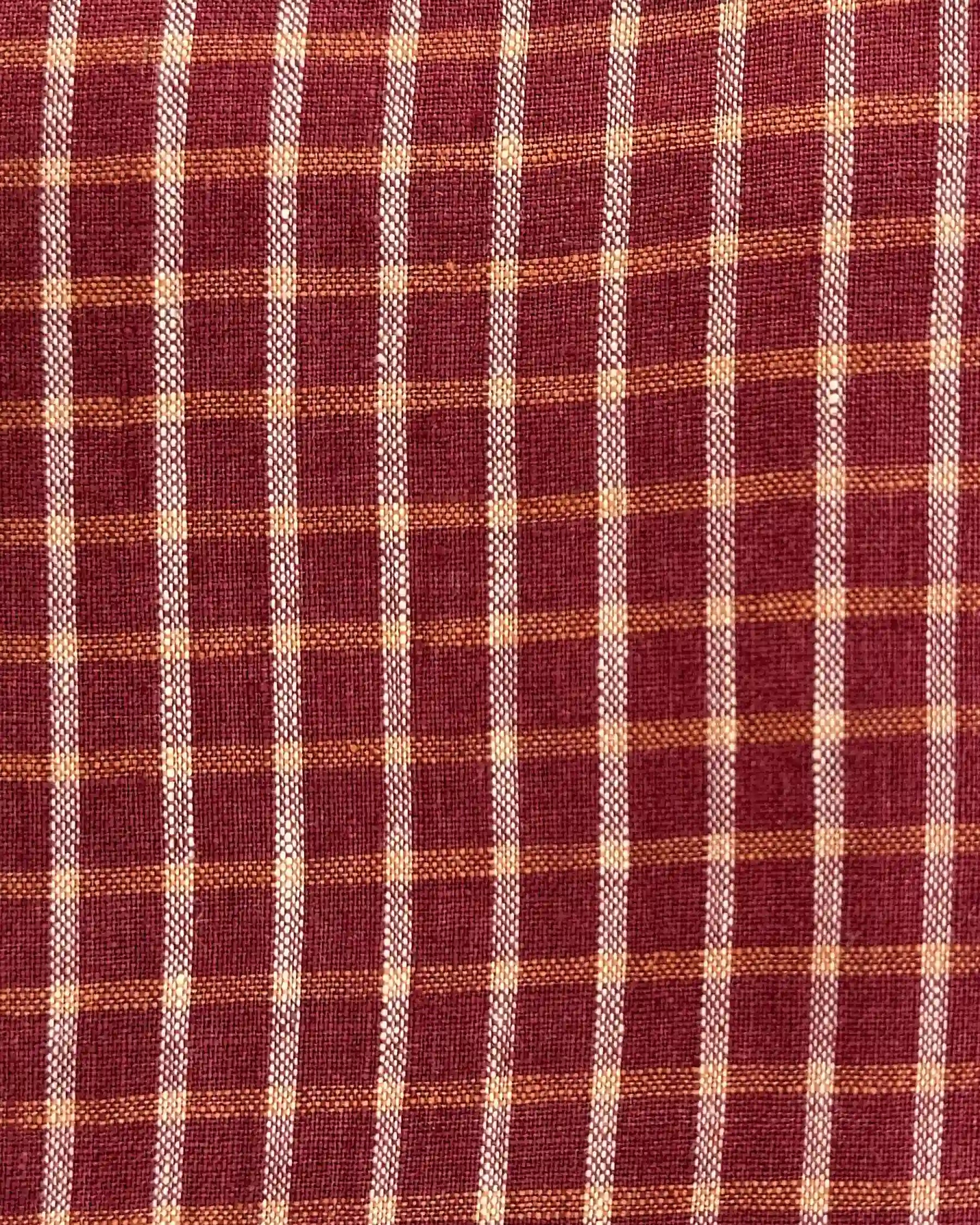 Close-up of the woven texture on Pyne and Smith Clothiers' No.30 Collared Linen Dress in Pomodoro Plaid, featuring a vintage-inspired checkered pattern with red, orange, and beige stripes forming small squares.